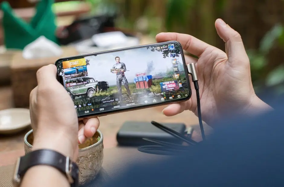 Pemain sedang asyik bermain game mobile di warung kopi pinggir pantai Namlea